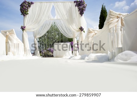 Festive wedding ceremony decoration of lightweight white fabric with light aisle on purple violet and gtreen natural background, horizontal picture