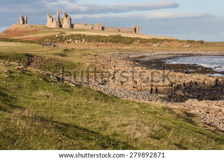 Dunstanburgh castle on Northumberland coast in North-East England Royalty-Free Stock Photo #279892871