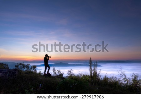 silhouette of photographer taking picture on landscape at doi phatang chiang rai, thailand