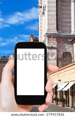 travel concept - tourist photograph Piazza Trento e Trieste with Town Hall and Cathedral in Ferrara, Italy on smartphone with cut out screen with blank place for advertising logo