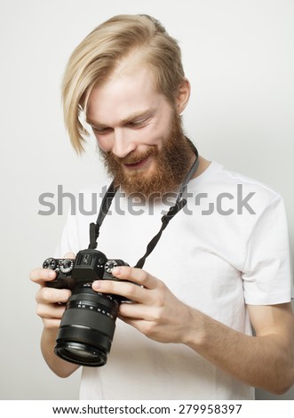 life style, tehnology and people concept: professional photographer. Portrait of confident young man in shirt  holding  camera over white background