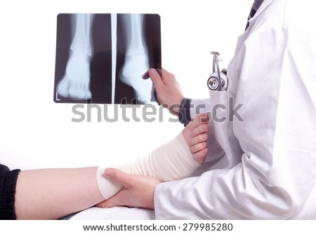 The doctor examines an X-ray picture , while the patient's sprained foot resting in his hand