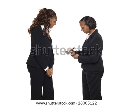 Stock photo of an African American businesswoman answering a questionaire being taken by another businesswoman.
