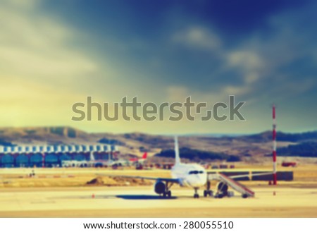 Blurred background : Airplane at the terminal gate Modern international airport at sunset. Vintage picture. Business and Travel concept