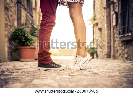 Couple kissing outdoors - Lovers on a romantic date at sunset,girls stands on tiptoe to kiss her man - Close up on shoes Royalty-Free Stock Photo #280073906