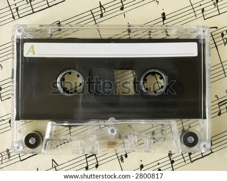 Cassette on old sheet music, closeup