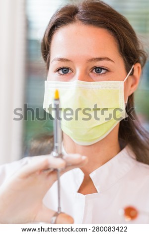 Female dentist focused on preparing dental anesthesia syringe.