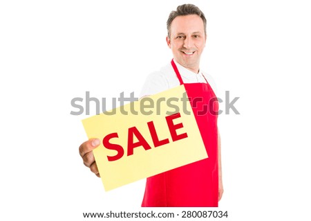 Supermarket employee holding sale sign and smiling to the camera