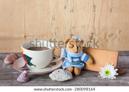 board with coffee and flower on wooden table in vintage tone