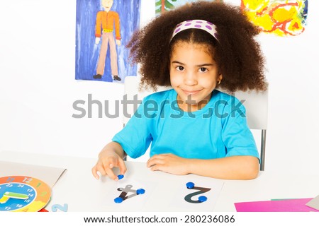 Cute African girl learn numbers with coins