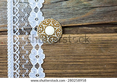vintage button and lace tape on old wooden surface