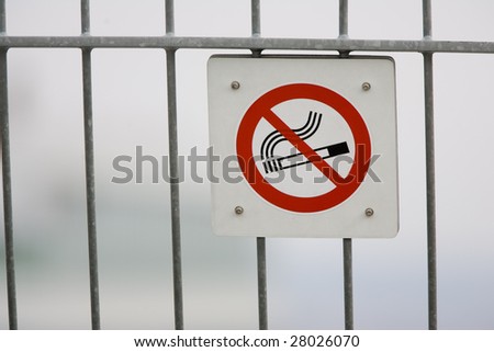 A no smoking sign posted on a fence.
