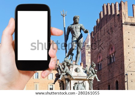 travel concept - tourist photograph Fountain of Neptune on Piazza del Nettuno in Bologna in sunny day, Italy on smartphone with cut out screen with blank place for advertising logo