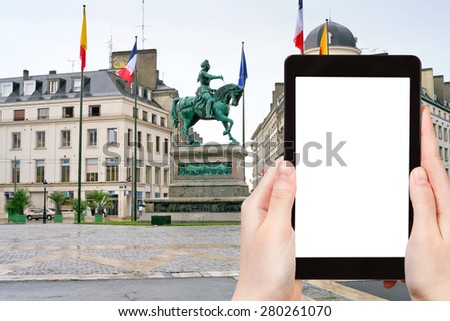 travel concept - tourist photograph monument of Jeanne d Arc on Place du Martroi in Orleans, France on tablet pc with cut out screen with blank place for advertising logo
