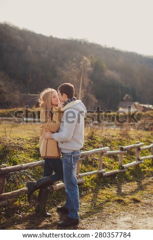 Affectionate young couple.  Pretty summer sunny outdoor portrait of young stylish couple while kissing on the street.