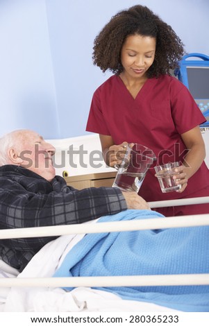 Nurse giving glass of water to senior man in hospital