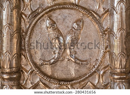 Two fish on minted silver surface, decoration of the temple in India