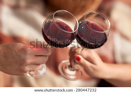 Man and woman drinking red wine. In the picture, close-up hands with glasses. They are celebrating their wedding anniversary.