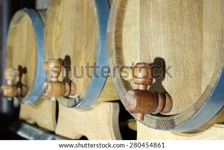 Three oak wooden barrels with a focus on taps. Shallow depth of field.