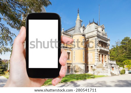 travel concept - tourist photograph Masandra Palace of Emperor Alexander III in Crimea on smartphone with cut out screen with blank place for advertising logo
