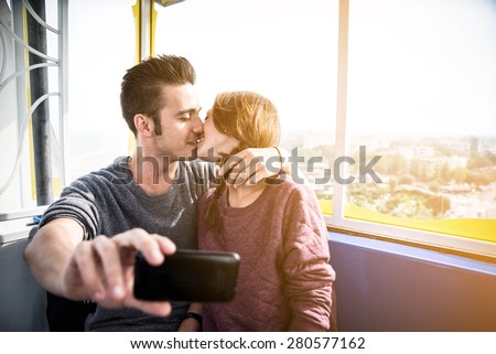 couple in love is taking a selfie on the ferris wheel