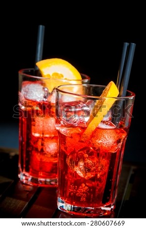 spritz aperitif aperol cocktail with orange slices and ice cubes on wood table and black background