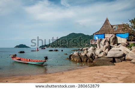 Red boat and blue house on a clear vacation background in Thailand.
