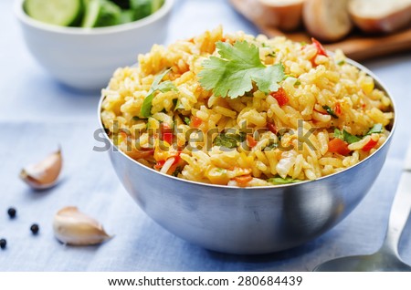 saffron rice with vegetables and cilantro on a blue background. the toning. selective focus  Royalty-Free Stock Photo #280684439