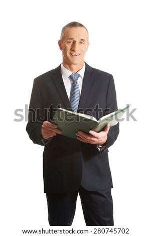 Businessman reading his note book.