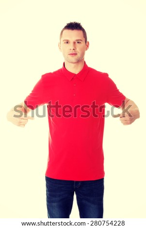 Excited man pointing on copy space on his tshirt