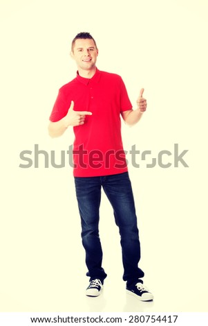 Excited man pointing on copy space on his tshirt