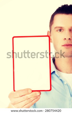 Happy young man showing and displaying placard with copy space