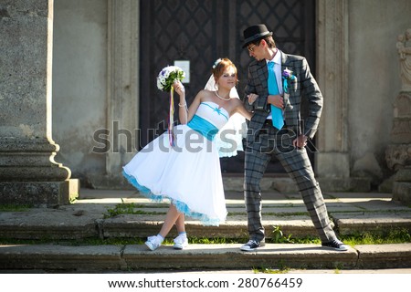 bride holds fiance for hand on the background old door