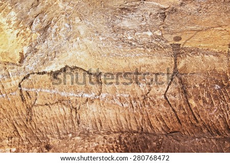 Buffalo hunting. Paint of human hunting on sandstone wall,  prehistoric picture. Black carbon abstract children art in sandstone cave
