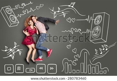Happy valentines love story concept of a romantic couple sharing headphones and listening to the music against chalk drawings background of acoustic system, equalizer and player icons.