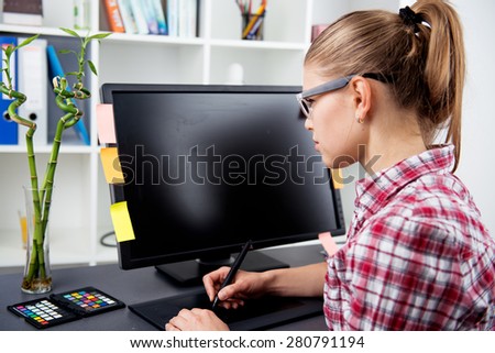 Woman graphic artist working with color palette and computer in creative studio. Post production concept.
