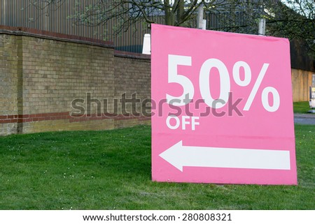 Discount 50% OFF display sign on grass closeup