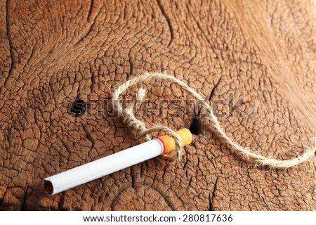 Cigarette and rope in hanging knot action represent the stop smoking concept related idea.