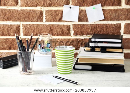 Stylish workplace at home or studio, on brown bricks background