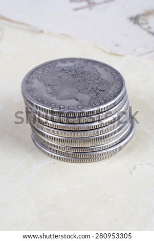 stack of silver dollar coins on old paper