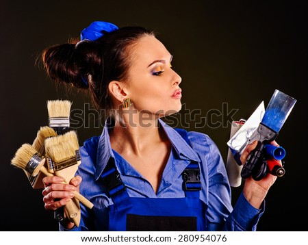 Builder woman holding paint brushes . Fashion
