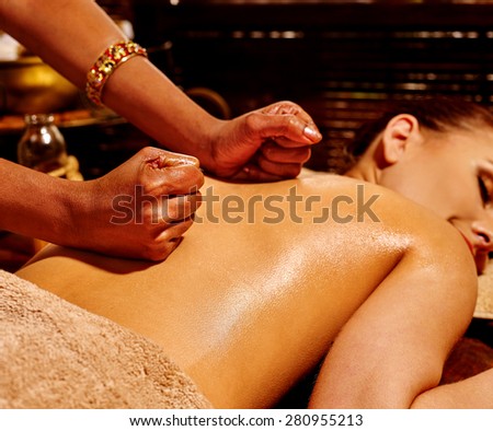 Young woman having oil Ayurveda spa treatment. Indian hands.