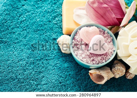 Spa setting with bath salt  and bath accessories on blue towel