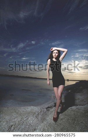 Portrait of fashionable girl running at the seaside .Fashio colors. Wide angle.