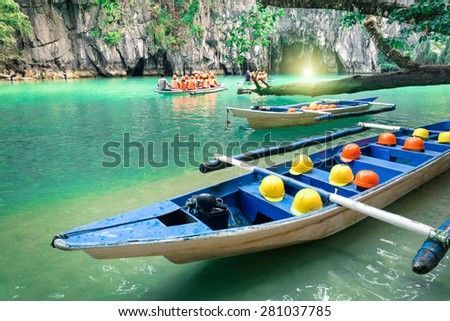 Longtail boats at cave entrance of Puerto Princesa subterranean underground river - Nature trip in Palawan exclusive Philippines destination - People with light equipment during adventurous excursion Royalty-Free Stock Photo #281037785
