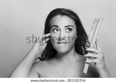 woman holding a wire brush as if she is going to use it to exfoliant hers skin