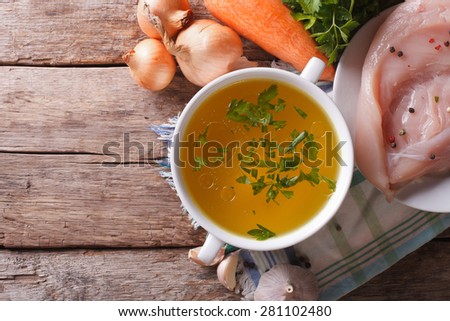 Country style: the chicken broth and the ingredients on the table. vertical view above, homemade food
