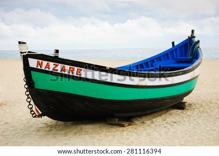 Traditional colorful  boat on the beach of Nazare (Portugal)