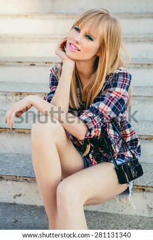 young beautiful happy stylish hipster girl, denim outfit, flirty happy, cool vintage style, having fun, sitting, stairs, oldschool film camera, photo, flirty, blond, smiling