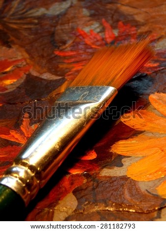 Royalty Free Photograph - Isolated Close Up Photographic Image of a Green Handled Artist's Paint Brush lying on the Colorful Brush Strokes of the Completed Painting
